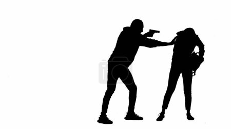 Photo for Robbery and criminal concept. Black silhouettes of thief and victim on white isolated background. A girl is walking carelessly, a male robber with a gun attacks her, the girl gives him a smartphone - Royalty Free Image