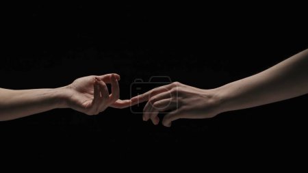 Photo for Body parts aesthetic beauty and skincare creative advertisement concept. Portrait of female model isolated on black background in studio. Two women naked hands stretching to each other touch fingers. - Royalty Free Image