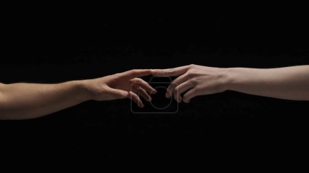 Photo for Body parts aesthetic beauty and skincare creative advertisement concept. Portrait of models hands isolated on black background. Man and woman naked hands lending to each other and touch fingers. - Royalty Free Image