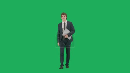 Foto de Concepto de hombre de negocios moderno. Modelo masculino en traje aislado sobre fondo de pantalla verde con croma key. Joven hombre de negocios con estilo en un traje azul con una carpeta gris en sus manos - Imagen libre de derechos