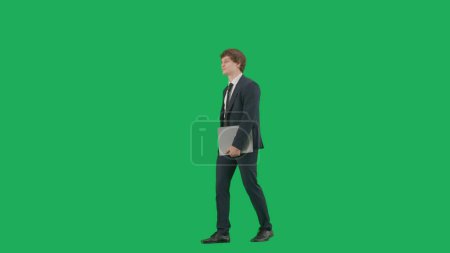 Téléchargez les photos : Concept d'homme d'affaires moderne. Modèle masculin en costume isolé sur fond d'écran vert avec clé chromatique. Jeune homme d'affaires élégant en costume bleu avec un dossier gris dans les mains - en image libre de droit