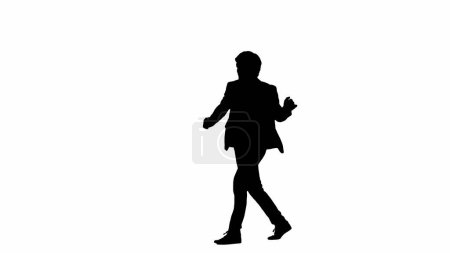 Foto de Moderno empresario creativo concepto de publicidad. Modelo masculino vista lateral en estudio aislado sobre fondo blanco con canal alfa. Silueta de hombre de negocios en traje caminando y bailando alegremente. - Imagen libre de derechos