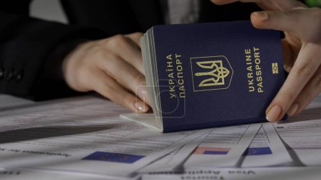 Téléchargez les photos : Passeport et migration concept publicitaire créatif. Gros plan sur les documents de demande de visa des États-Unis et de l'Union européenne. Travailleuse titulaire d'un passeport ukrainien. - en image libre de droit