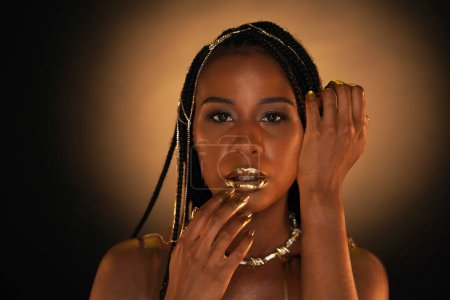 Téléchargez les photos : Portrait d'une femme afro-américaine avec un collier en or et des chaînes en or dans ses cheveux. Les modèles lèvres, doigts et ongles sont recouverts d'or liquide. Ferme là. Le concept de beauté - en image libre de droit