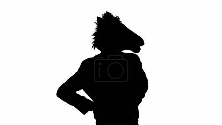 Téléchargez les photos : Silhouette noire de l'homme en costume d'affaires avec masque de tête de cheval sur fond de studio isolé blanc - en image libre de droit