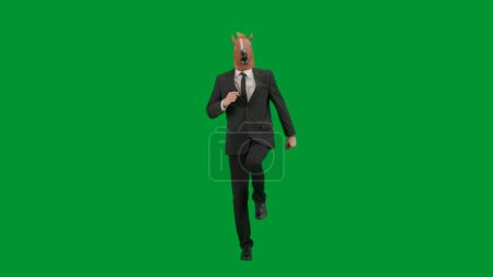 Téléchargez les photos : Homme en costume d'affaires avec masque de tête de cheval sur fond de studio vert. Homme d'affaires marchant, rebondissant et dansant. Concept de travail de bureau dur - en image libre de droit