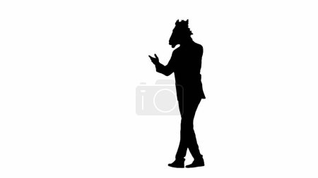 Téléchargez les photos : Silhouette noire de l'homme en costume d'affaires avec masque de tête de cheval sur fond de studio isolé blanc. Homme d'affaires marchant et parlant sur smartphone. Concept de travail de bureau dur - en image libre de droit