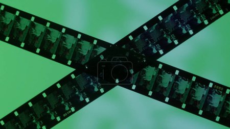 Photo for Crossed stripes of photographic film on green background close up. Negatives of photographic film showing animals, cows, close up - Royalty Free Image