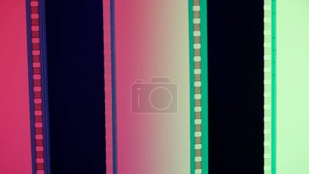 Téléchargez les photos : Deux bandes de film verticales sur fond dégradé rouge et vert, rapprochées. Cadre de diapositive de film 35mm. Long, cadre de bande de film rétro. Espace de copie - en image libre de droit