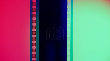 Photo for Vertical film strip on a red and green background, close up. 35mm film slide frame. Long, retro film strip frame. Copy space - Royalty Free Image