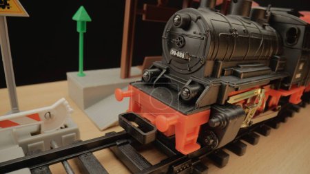 Téléchargez les photos : Locomotive noire de train à vapeur en plastique pour enfants en gros plan. Plan parfait pour une utilisation dans les présentations d'enfants ou la publicité de jouets - en image libre de droit