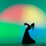 Modern choreography an dance. Woman silhouette dancing on colorful background. Graceful dancer passionately dancing flamenco performing elements of Spanish style choreography.