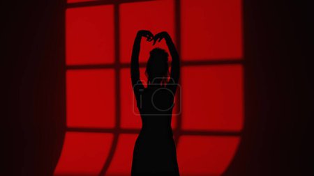 Photo for Modern dance choreography. Female silhouette of dancer dancing against window shade. Woman in flamenco style dress performs elegant Spanish dance movements with hands and body in studio - Royalty Free Image