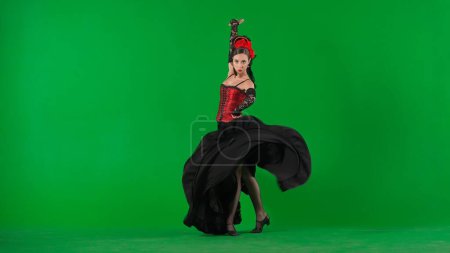 Téléchargez les photos : Chorégraphie moderne une danse. Femme danseuse dansant sur écran vert chroma key. Femme en robe de style flamenco effectue des mouvements élégants de danse espagnole avec ses mains et son corps dans le studio. - en image libre de droit