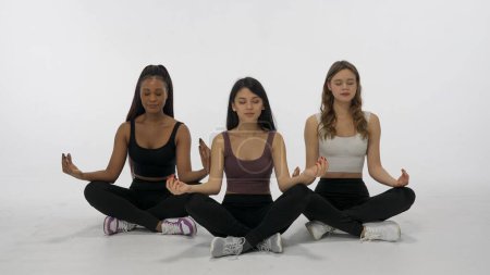 Photo for Portrait of young multiethnic models isolated on white background. Group of three positive multiracial girls meditating and laughing at camera Multiethnic beauty concept - Royalty Free Image