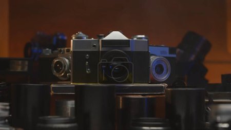 Photo for Vintage collection of old vintage cameras and lenses. Plunge into the atmosphere of professional photography of the last century Soft light and smoke emphasize creativity and antiquity of the devices - Royalty Free Image