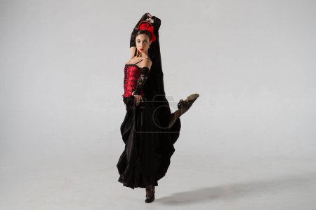 Photo for Modern choreography an dance. Woman dancer dancing on white background. Female in flamenco style dress performs elegant spanish dance moves with her hands and body in the studio. - Royalty Free Image