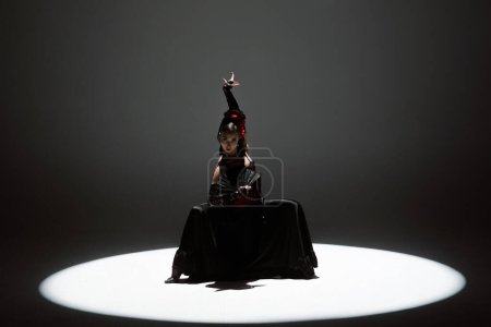 Foto de Coreografía moderna un baile. Mujer bailando sobre fondo negro bajo focos. Bailarina española en traje rojo-negro elementos de baile de flamenco apasionado. - Imagen libre de derechos
