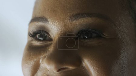 Téléchargez les photos : Traitement de la vue concept de services ophtalmologiques. Macro shot de visage de mannequin féminin. Femme afro-américaine tourné visage recadré, les yeux verts regardant loin de la caméra. - en image libre de droit