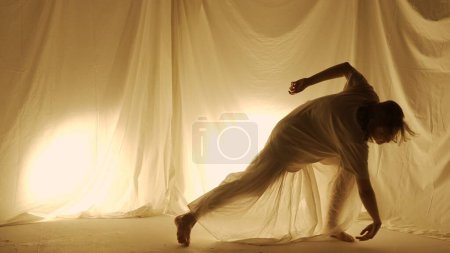 Téléchargez les photos : Concept de chorégraphie expérimentale contemporaine Silhouette. Une danseuse en studio. Jeune fille dansant contre la lumière du dos chaud. - en image libre de droit