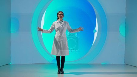 Téléchargez les photos : Une femme professionnelle en blouse blanche se tient devant un produit pharmaceutique sur un grand écran numérique donnant une conférence scientifique. Le concept de médecine, de santé et de soins de santé. - en image libre de droit