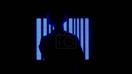 Téléchargez les photos : Concept de technologie visuelle numérique. Homme contre grand mur numérique. Silhouette d'homme posant devant le mur d'écran numérique avec fond de symboles néon dans le club sombre. - en image libre de droit