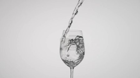 Foto de Una copa de vino prístina está llena de agua clara y espumosa en un vertido controlado, establecido en un fondo limpio y blanco. La imagen captura la elegancia del vaso y la pureza del agua en - Imagen libre de derechos