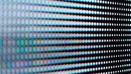 Eine detaillierte Nahaufnahme eines digitalen LED-Panels. Das Bild hebt die einzelnen RGB-Pixel hervor, die in einem Raster angeordnet sind, und veranschaulicht die komplexe Technologie hinter elektronischen Displays.