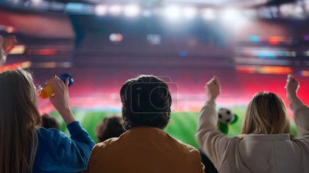 Foto de Una electrizante instantánea de los aficionados al fútbol silueta en una arena deportiva, brazos levantados en alto en celebración, cautivados por la acción en el estadio, inmersos en la pasión compartida del momento. - Imagen libre de derechos