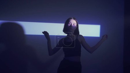 Photo for Catch the beat with this dynamic hip-hop dance video. A female dancer throws down an impressive set, silhouetted by a bright spotlight that echoes the vitality of the performance. - Royalty Free Image