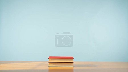 Foto de Dos libros sobre una mesa de madera sobre un relajante fondo azul pastel. Un homenaje al encanto atemporal de la lectura y el conocimiento. Ficción.. - Imagen libre de derechos