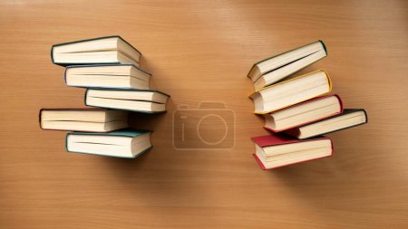 Foto de Una vista aérea de filas de libros con cubiertas de colores en una mesa de madera. El concepto de aprendizaje y conocimiento. Una colección de ficción. - Imagen libre de derechos