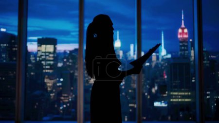 Photo for Corporate business advertisement concept. Successful business woman in the office. Woman ceo hedge fund top manager in front of window with evening city view talking on smartphone holding papers. - Royalty Free Image