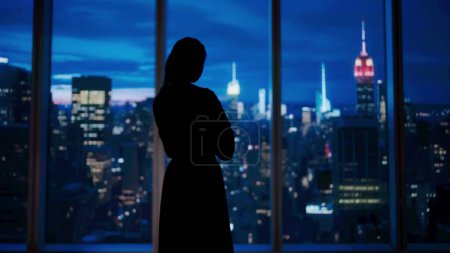 Photo for Corporate business advertisement concept. Successful business woman in the office. Woman ceo hedge fund top manager in front of window with evening city view standing looking outside. - Royalty Free Image