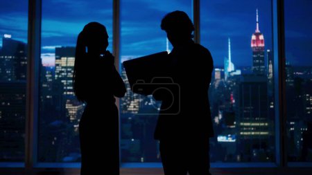 Photo for Corporate business advertisement concept. Successful business people in the office. Man and woman ceo hedge fund top manager talking holding laptop in front of window with evening city view. - Royalty Free Image