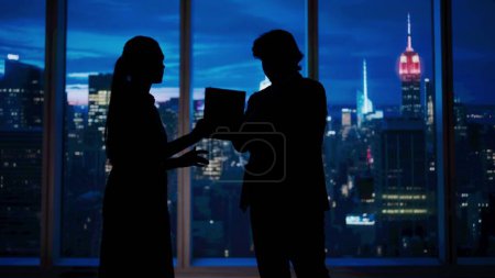 Photo for Corporate business advertisement concept. Successful business people in the office. Man and woman ceo hedge fund top manager talking holding tablet in front of window with evening city view. - Royalty Free Image