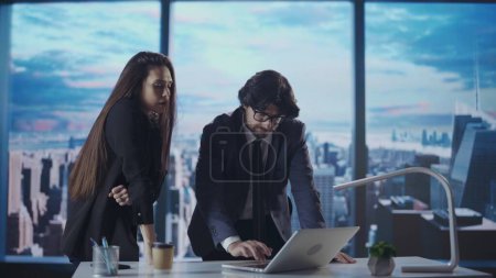 Photo for Corporate business advertisement concept. Successful business people in the office. Man and woman ceo hedge fund top manager at desk talking looking at laptop in front of window with morning city view - Royalty Free Image