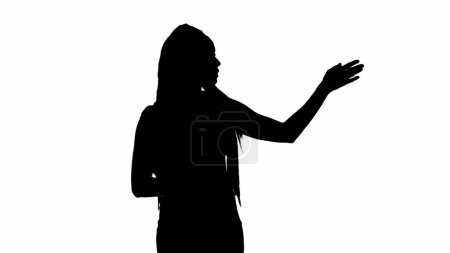 Téléchargez les photos : Reportage TV et concept de publicité de diffusion en direct. Femme reporter silhouette noire sur fond blanc avec canal alpha. afro-américaine femme news hôte avec tablette parler spectacles vide - en image libre de droit