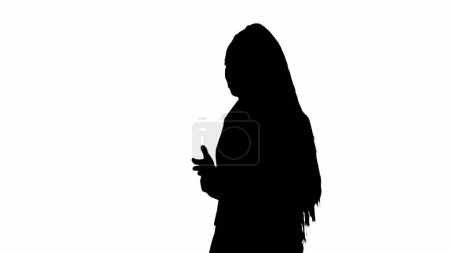 Photo for Tv news report and live broadcasting advertisement concept. Female reporter black silhouette on white background with alpha channel. African American woman news host in suit walks and talks, side view - Royalty Free Image