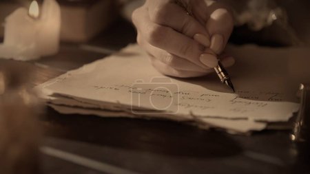 Photo for Historical letter creative concept. Female in antique outfit writes with feather pen. Close up shot of woman writing a letter with vintage quill on old parchment paper. - Royalty Free Image