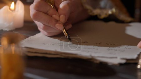 Foto de Carta histórica concepto creativo. Mujer en traje antiguo escribe con pluma de pluma. Primer plano de la mujer escribiendo una carta con pluma vintage en papel pergamino viejo. - Imagen libre de derechos