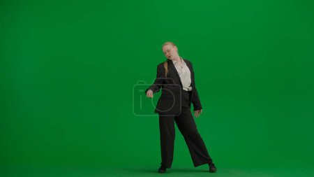Foto de Mujer en traje negro de negocios bailando alegremente en pantalla verde con cromakey. Moderno concepto de publicidad creativa mujer de negocios. - Imagen libre de derechos