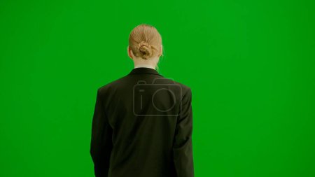 Photo for Modern businesswoman creative advertisement concept. Portrait of female in suit on chroma key green screen. Blonde business woman in formal outfit walking. Back view. - Royalty Free Image