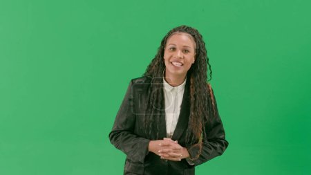 Photo for Tv news and live broadcasting concept. Young female reporter isolated on chroma key green screen background. African american woman tv news host talking smiling at camera. - Royalty Free Image