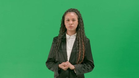 Photo for Tv news and live broadcasting concept. Young female reporter isolated on chroma key green screen background. African american woman tv news host talking with serious face. - Royalty Free Image