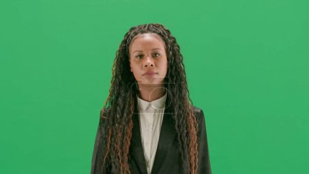 Tv news and live broadcasting concept. Young female reporter isolated on chroma key green screen background. African american woman tv news host walking.