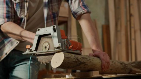 Photo for Carpentry and handicraft advertisement concept. Male woodworker working in garage. Man professional carpenter working with wooden materials in workshop sawing wood using electric circular saw. - Royalty Free Image