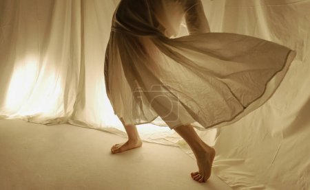 Téléchargez les photos : Vue abstraite d'une jupe tourbillonnante de danseurs dans un jeu de lumière et d'ombres. - en image libre de droit