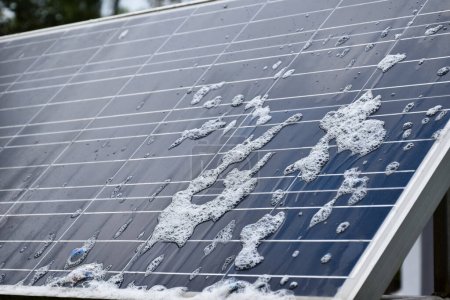 Nahaufnahme Photovoltaik-Panel mit Wassertropfen und Schwämmen auf der Oberfläche, weicher und selektiver Fokus, Konzept zur Nutzung natürlicher Energie im täglichen Leben auf der ganzen Welt.