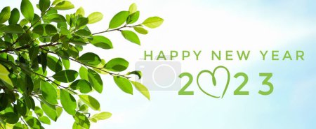 Foto de 'FELIZ AÑO NUEVO 2023' en color verde con ramas de ficus y hojas de fondo, concepto de tarjeta de invitación de saludo y feliz año nuevo 2023 concepto. - Imagen libre de derechos
